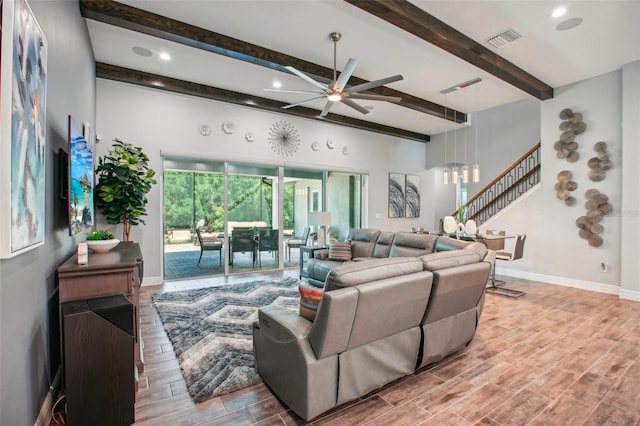 living area with visible vents, ceiling fan, baseboards, wood tiled floor, and stairway