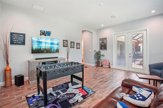 rec room featuring baseboards, french doors, arched walkways, and wood tiled floor