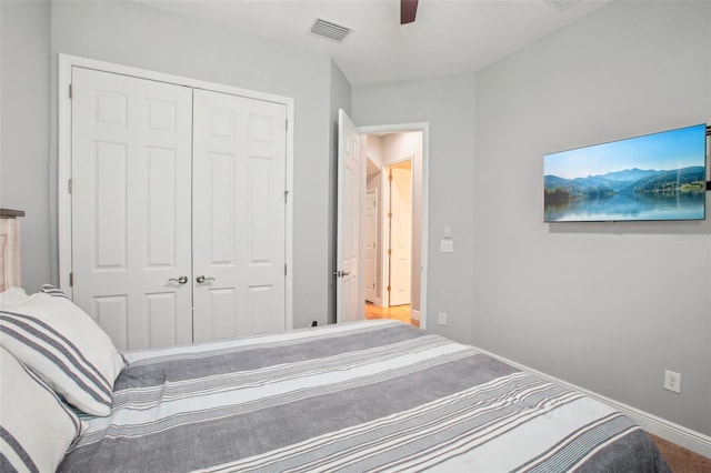 bedroom with a closet, visible vents, baseboards, and a ceiling fan