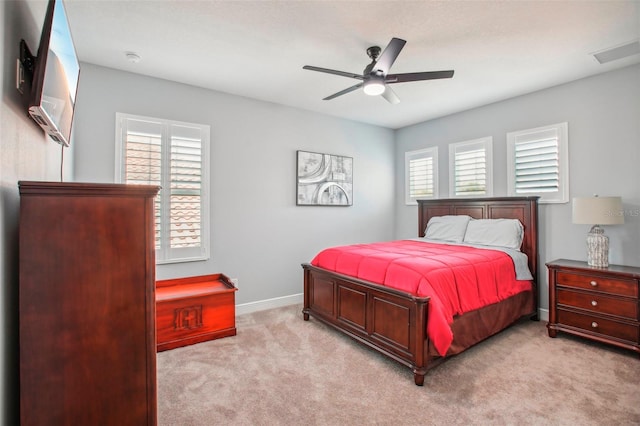 bedroom featuring visible vents, light colored carpet, baseboards, and ceiling fan