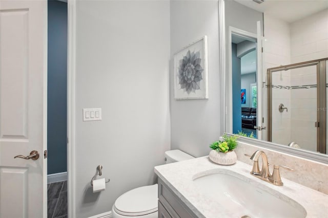 full bathroom featuring baseboards, toilet, a stall shower, and vanity