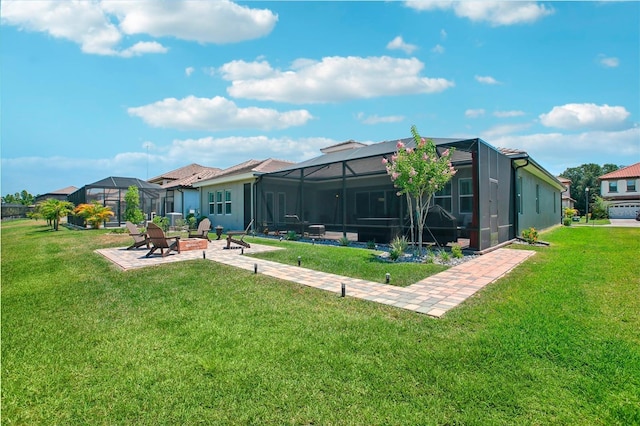 rear view of house with glass enclosure, a patio, a yard, and an outdoor fire pit