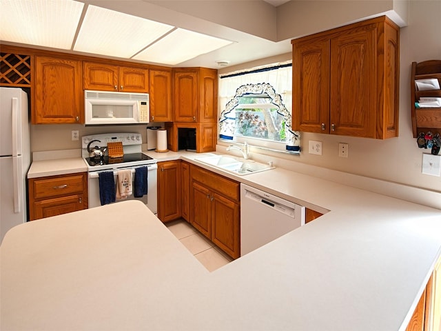 kitchen with white appliances, brown cabinets, and a sink