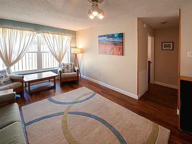 sitting room with a textured ceiling, wood finished floors, and baseboards