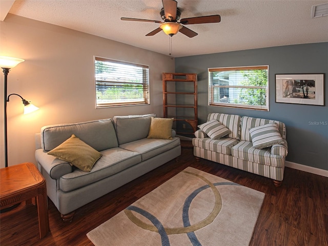 living area featuring a textured ceiling, wood finished floors, a ceiling fan, visible vents, and baseboards