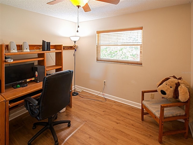 office area with light wood-style floors, ceiling fan, a textured ceiling, and baseboards