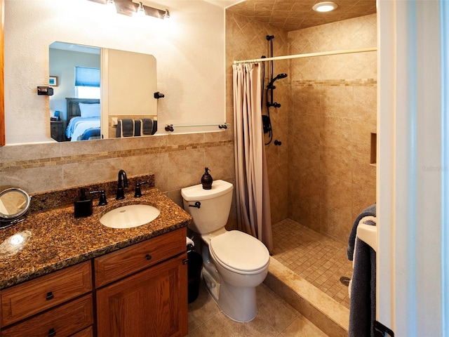 bathroom with toilet, vanity, tile walls, a stall shower, and ensuite bath