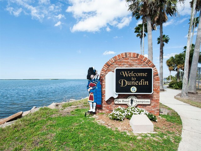 community / neighborhood sign featuring a water view