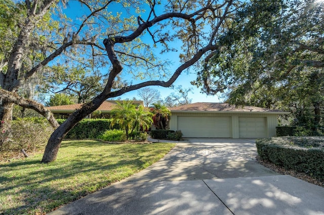 ranch-style home featuring a garage, a front lawn, and concrete driveway