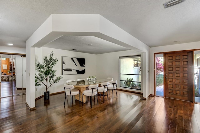 dining room with visible vents, baseboards, dark wood finished floors, and a textured ceiling