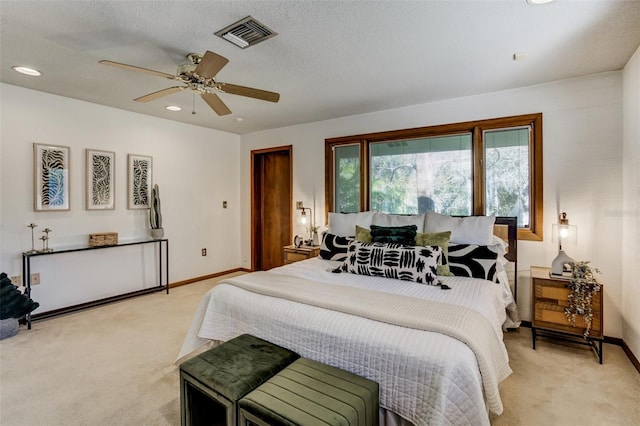 bedroom featuring a textured ceiling, baseboards, visible vents, and light colored carpet