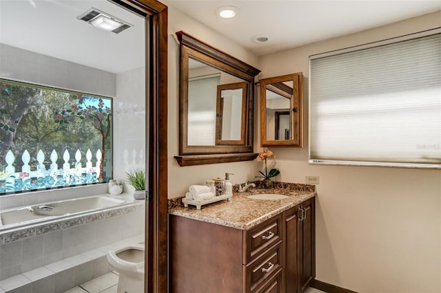 bathroom featuring visible vents, a garden tub, vanity, and toilet