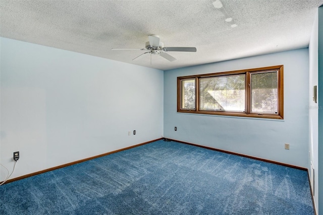 carpeted spare room featuring ceiling fan, a textured ceiling, and baseboards