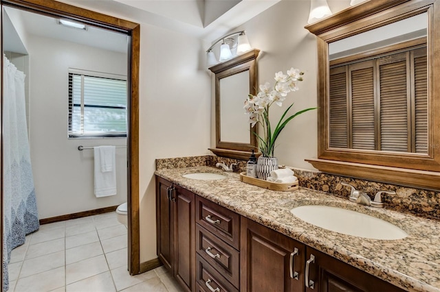 full bathroom with toilet, tile patterned flooring, double vanity, and a sink