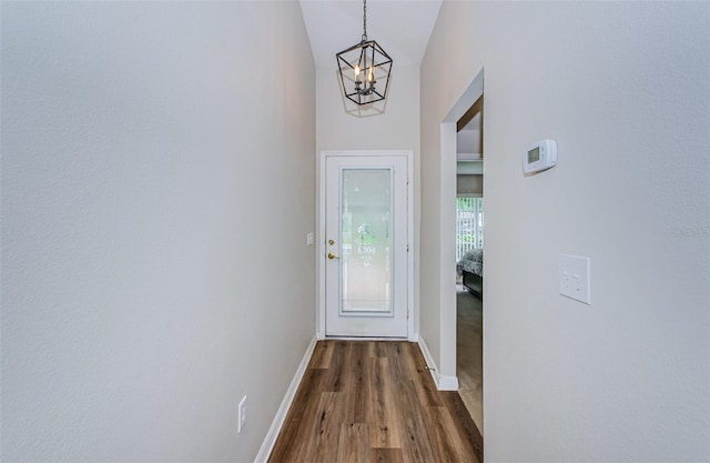 18186 Sandy Pointe Dr, Tampa, FL 33647 - doorway to outside with dark wood-type flooring, baseboards, vaulted ceiling, and a notable chandelier