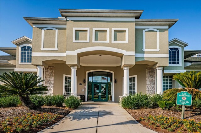 18186 Sandy Pointe Dr, Tampa, FL 33647 - exterior space featuring stucco siding, stone siding, and french doors