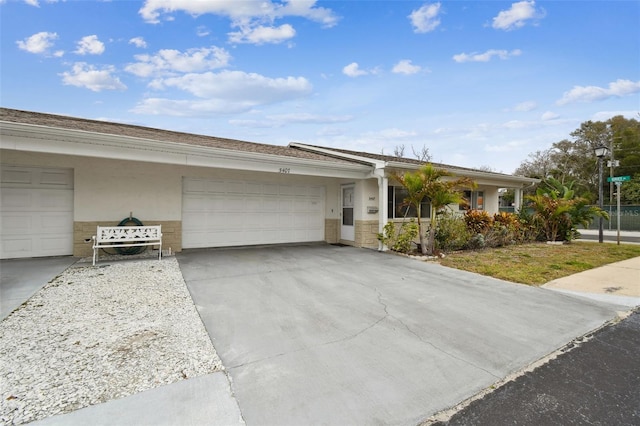 ranch-style house featuring a garage, concrete driveway, and stucco siding