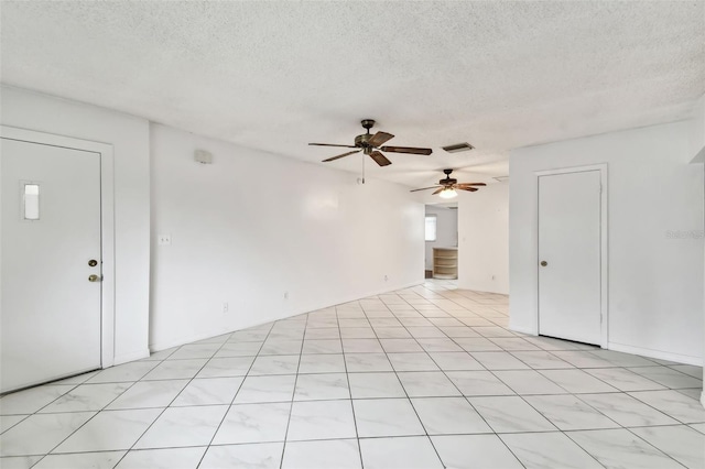 spare room featuring visible vents, ceiling fan, and a textured ceiling