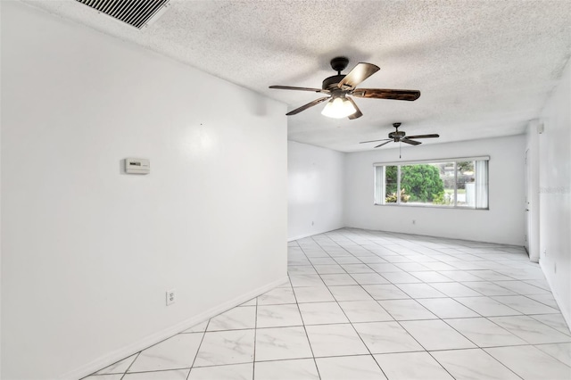 unfurnished room with visible vents, ceiling fan, and a textured ceiling