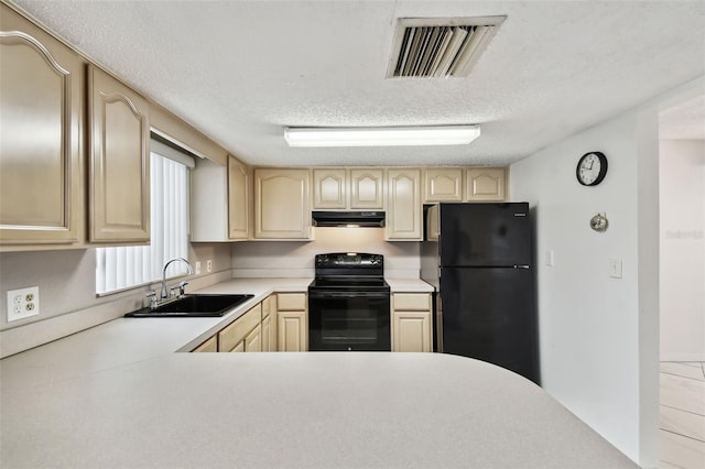 kitchen with visible vents, under cabinet range hood, light countertops, black appliances, and a sink