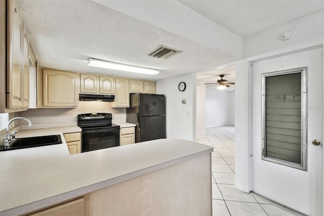 kitchen featuring under cabinet range hood, a sink, visible vents, light countertops, and black appliances