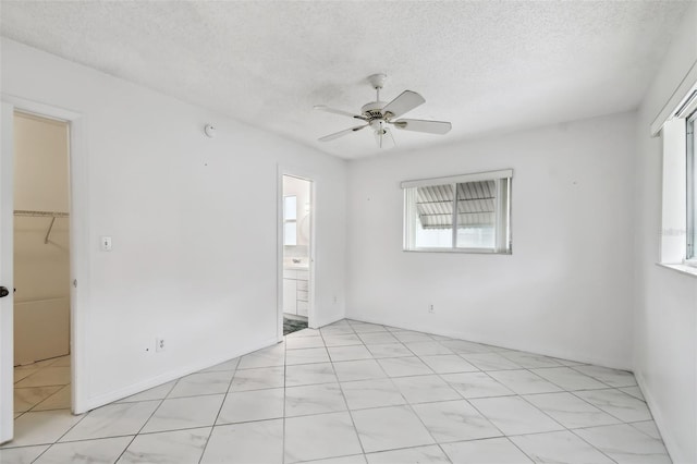 unfurnished room featuring ceiling fan and a textured ceiling