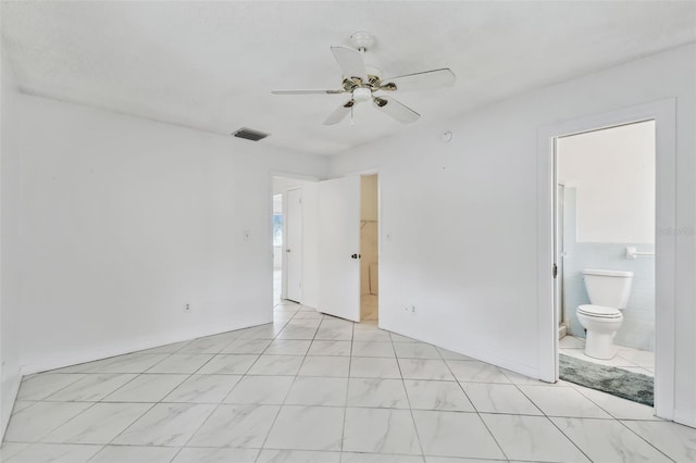 unfurnished bedroom with ceiling fan, visible vents, tile walls, and ensuite bathroom