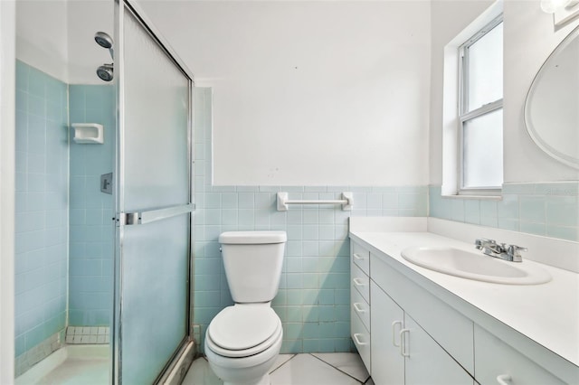 full bath with toilet, a wainscoted wall, vanity, a shower stall, and tile walls