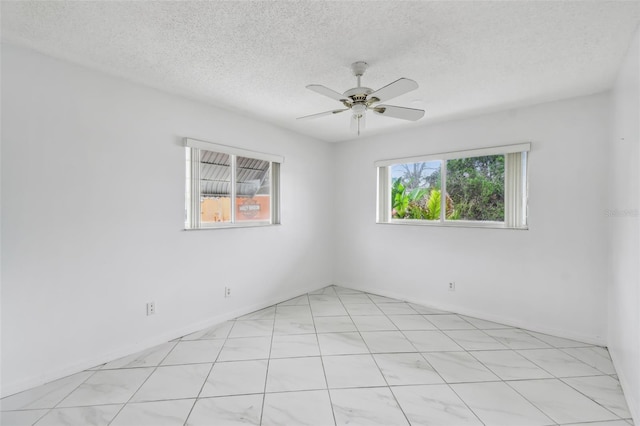 empty room with a healthy amount of sunlight, ceiling fan, and a textured ceiling