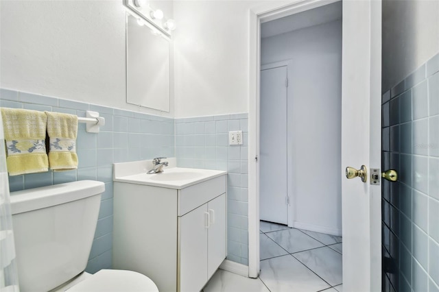 bathroom featuring toilet, tile walls, and vanity