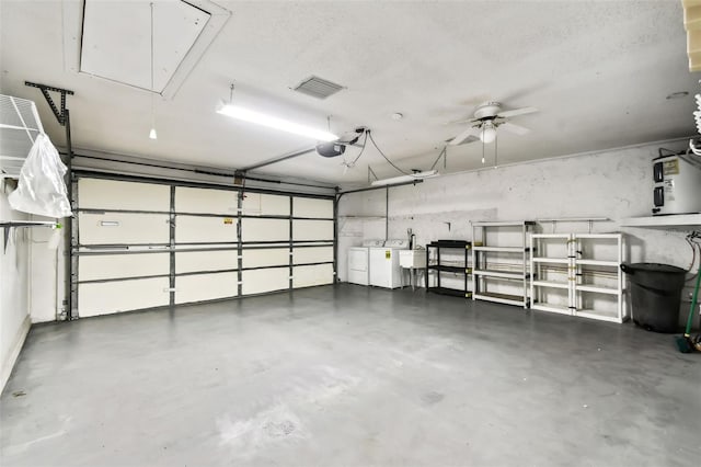 garage with water heater, visible vents, separate washer and dryer, and a sink