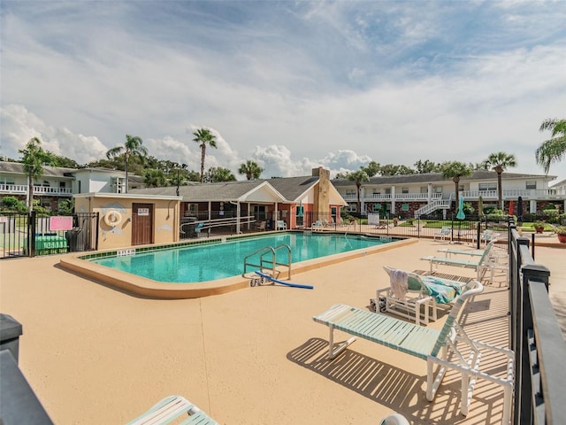 community pool featuring a patio and fence