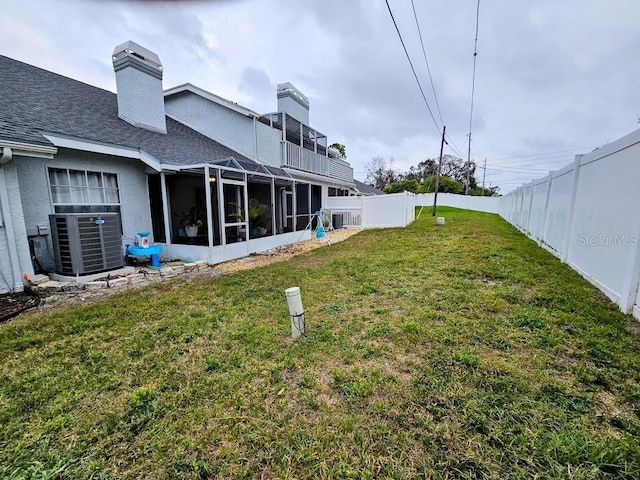 view of yard with central AC and a fenced backyard