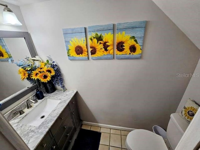 bathroom featuring toilet, tile patterned floors, baseboards, and vanity