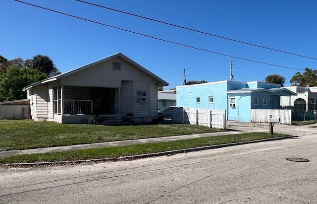 bungalow-style house with a front yard and fence