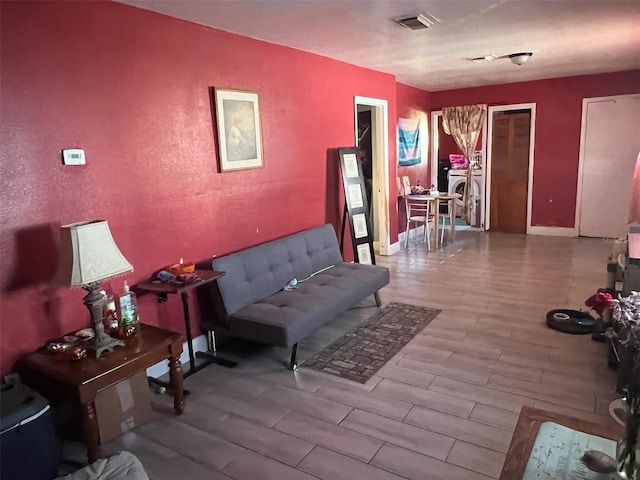 living area with wood finished floors and visible vents
