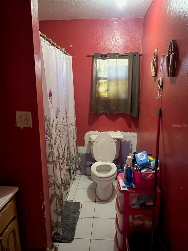 full bathroom featuring toilet, a textured ceiling, a shower with shower curtain, and tile patterned flooring