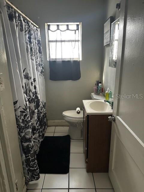 bathroom with toilet, vanity, a shower with shower curtain, and tile patterned flooring