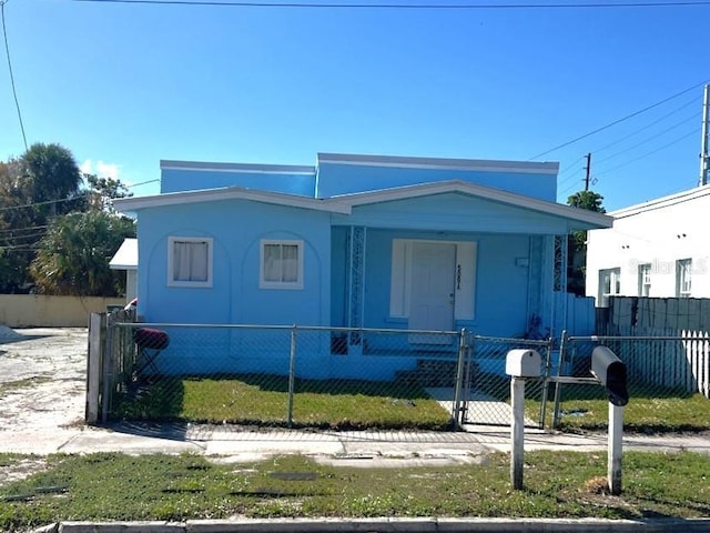 view of front of home featuring a fenced front yard, covered porch, and a gate