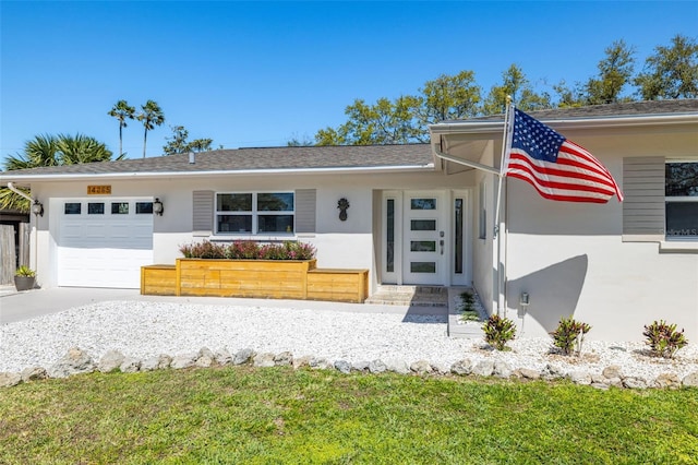 view of front of home with a garage, driveway, and stucco siding