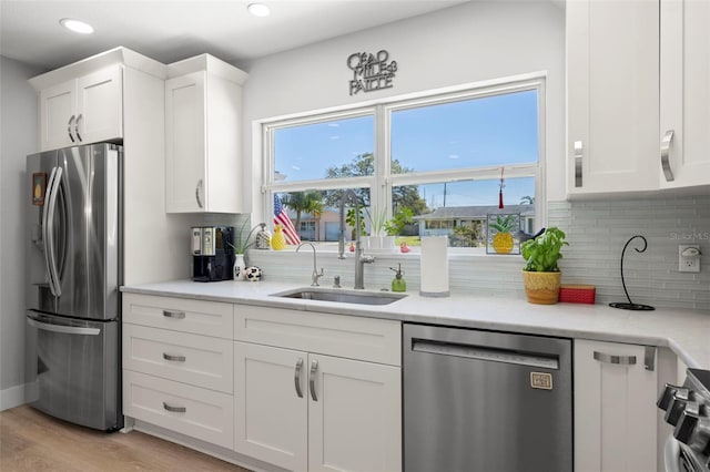 kitchen with stainless steel appliances, a wealth of natural light, a sink, and backsplash