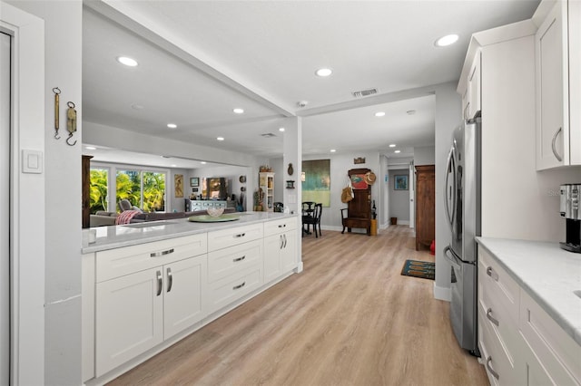 kitchen featuring recessed lighting, light countertops, freestanding refrigerator, open floor plan, and light wood-type flooring