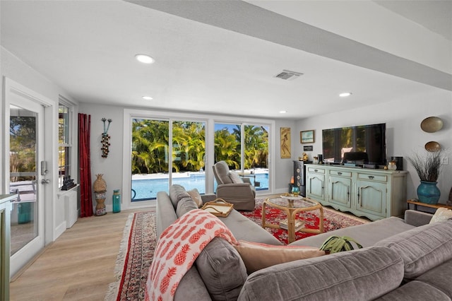 living area with light wood-style floors, visible vents, and recessed lighting