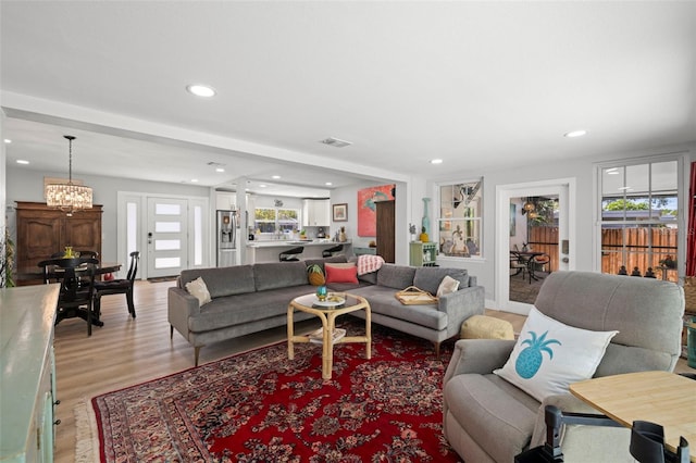 living area featuring recessed lighting, visible vents, plenty of natural light, and light wood-style flooring