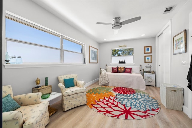 bedroom featuring a closet, multiple windows, wood finished floors, and visible vents