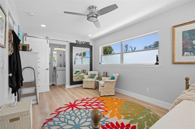 bedroom with light wood finished floors, a barn door, baseboards, ceiling fan, and recessed lighting