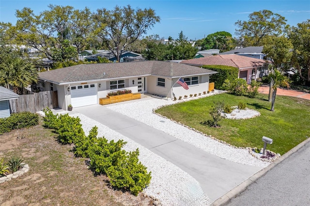 ranch-style house with driveway, an attached garage, fence, a front yard, and stucco siding