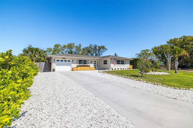 single story home featuring a garage, concrete driveway, fence, a front yard, and stucco siding