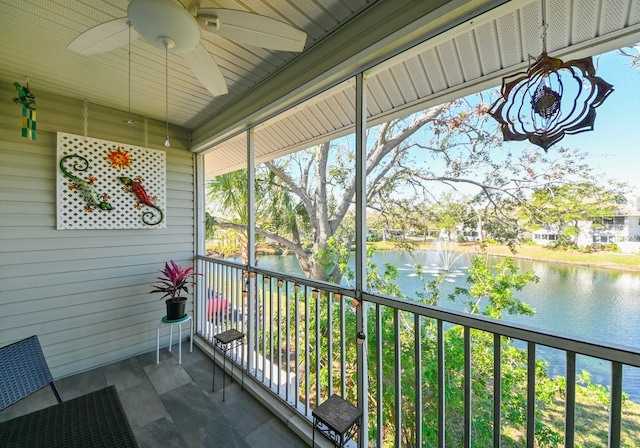 sunroom / solarium with a water view and ceiling fan