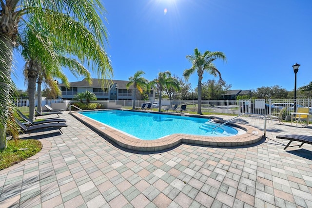 community pool featuring a patio and fence